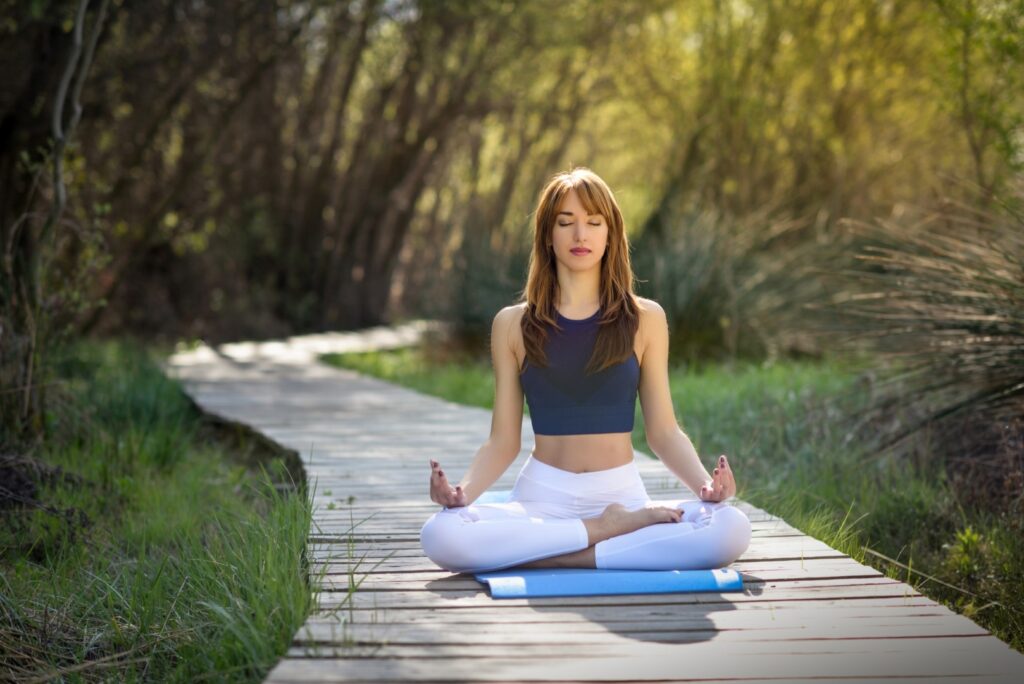 Une femme qui fait du yoga dans son jardin