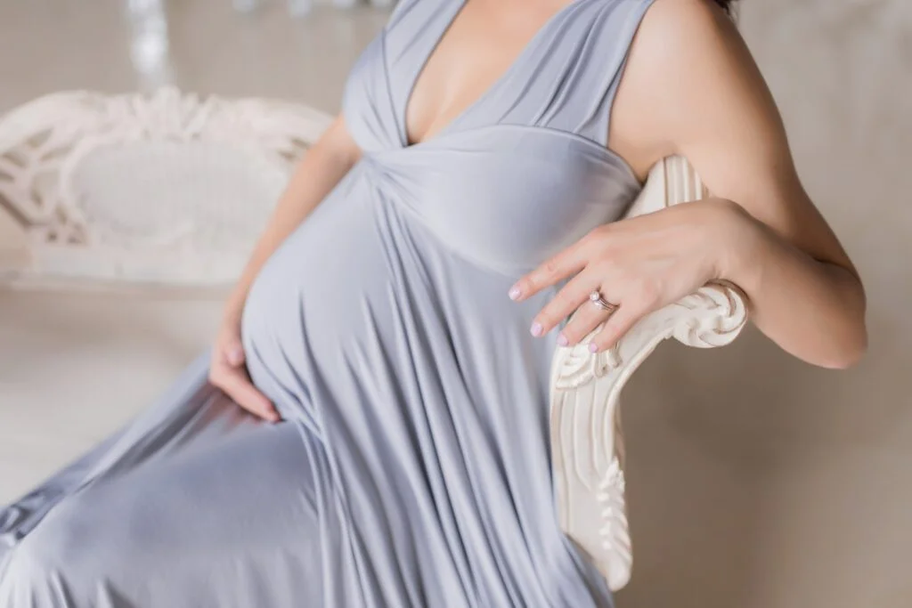 Une femme enceinte qui porte une belle robe et un bola de grossesse qui ne se voit pas