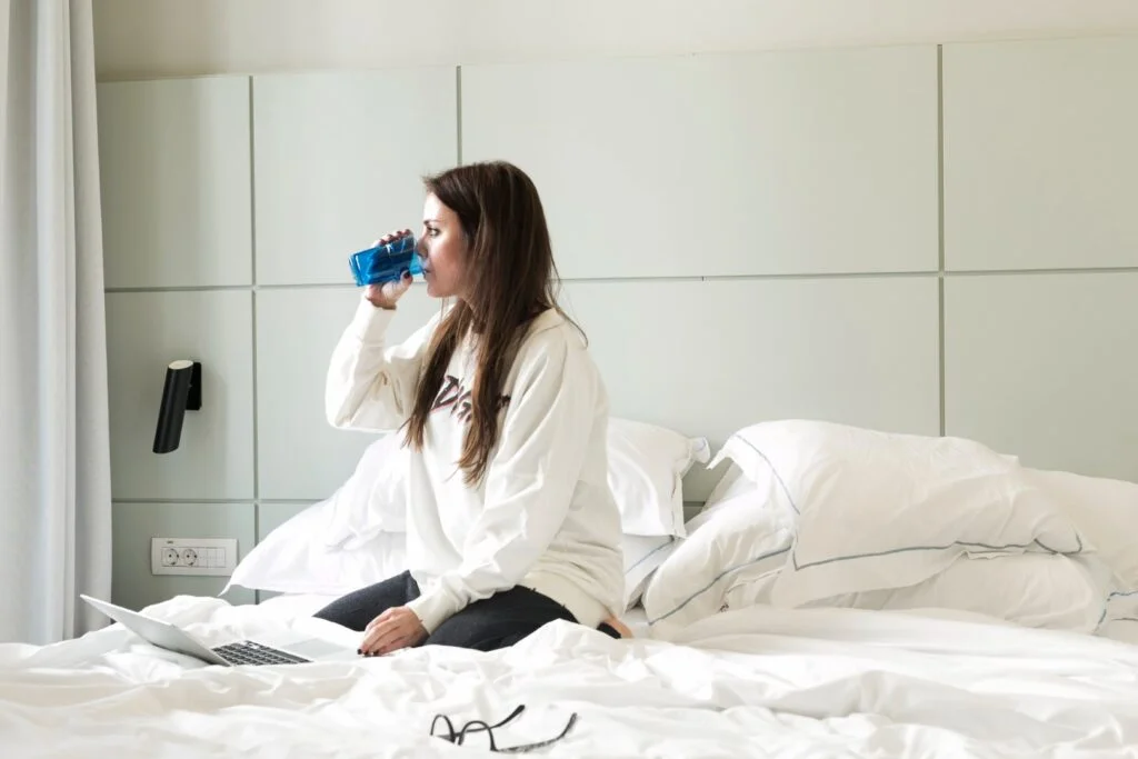 une femme qui boit un verre d'eau en se levant