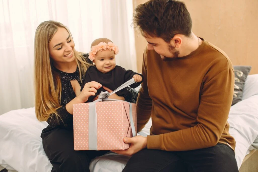 une famille avec un cadeau de naissance pour bébé
