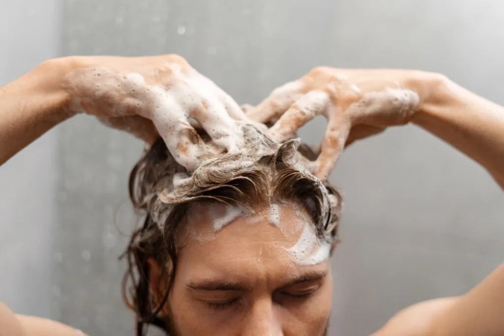 Une femme se lave les cheveux sous la douche