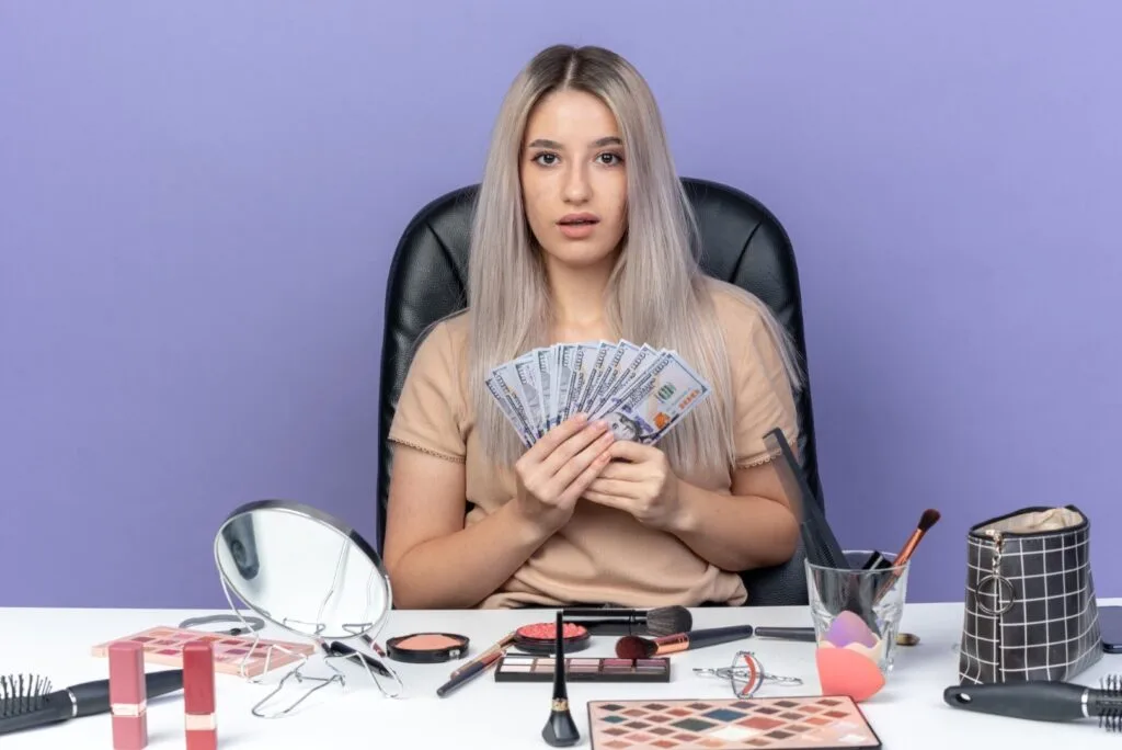 une jeune femme qui montre l'argent dépensé pour l'achat de maquillage