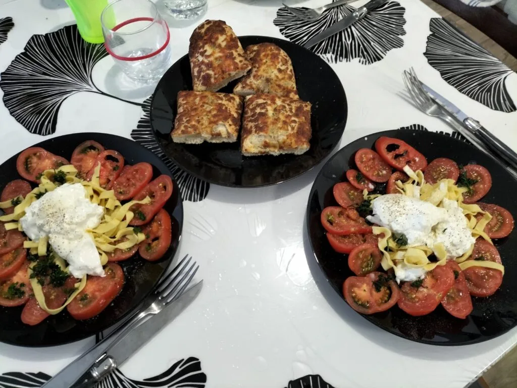 Salade de tomates, burrata et tagliatelles servies avec une focaccia