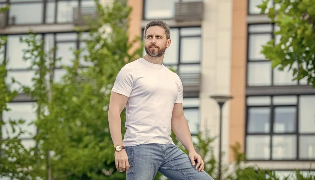 Homme portant un jean et un t-shirt blanc en extérieur
