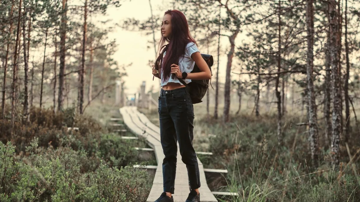 Femme marchant dans la nature sans téléphone, symbolisant la reconnection à soi et la pause numérique.