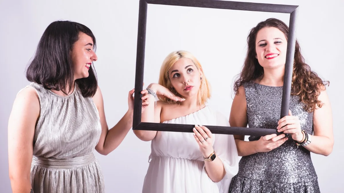 Femmes souriantes devant un miroir essayant une tenue de fêtes adaptée à leur morphologie