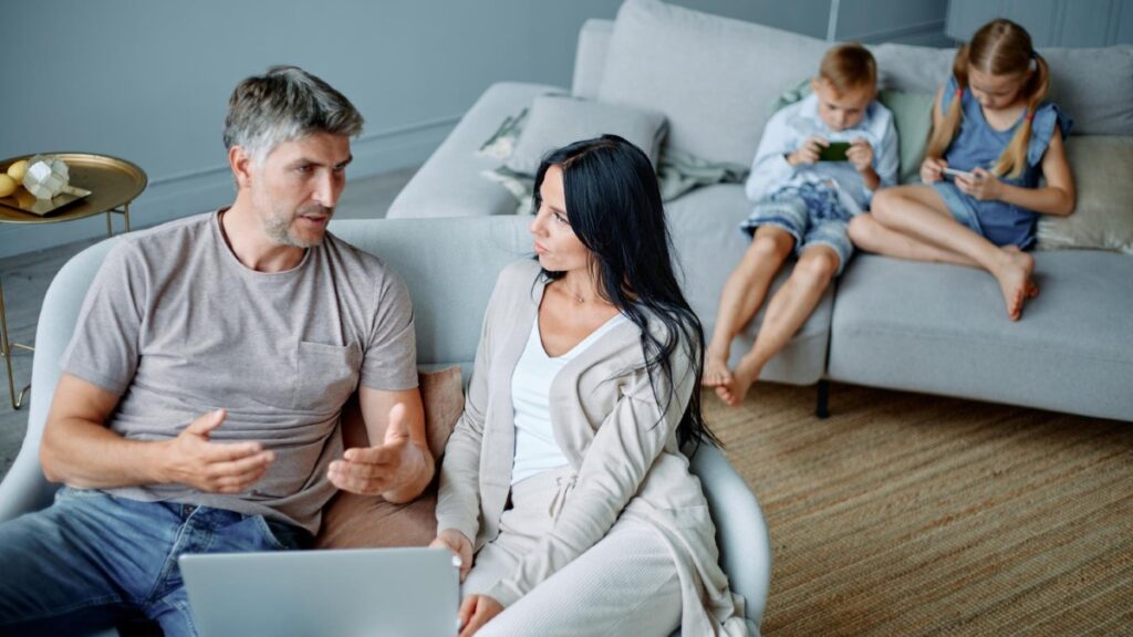 Famille assise dans un salon lumineux, échange calme mais émotionnel.
