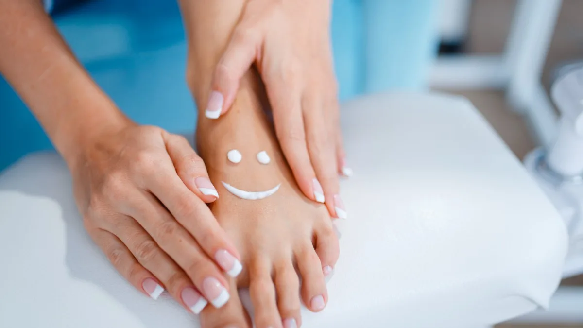 Application de crème sur les orteils pour une peau souple.