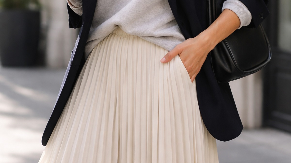 Jupe plissée portée avec un sweat et un blazer pour moderniser le style preppy