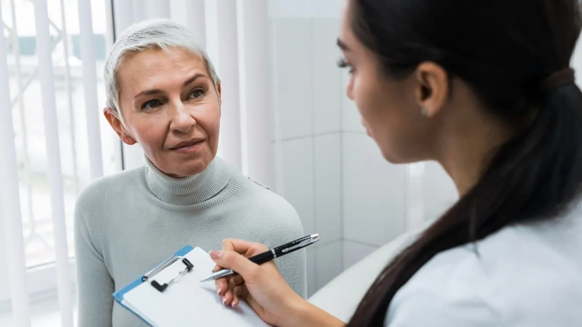 Femme échangeant avec un professionnel de santé dans une atmosphère rassurante.