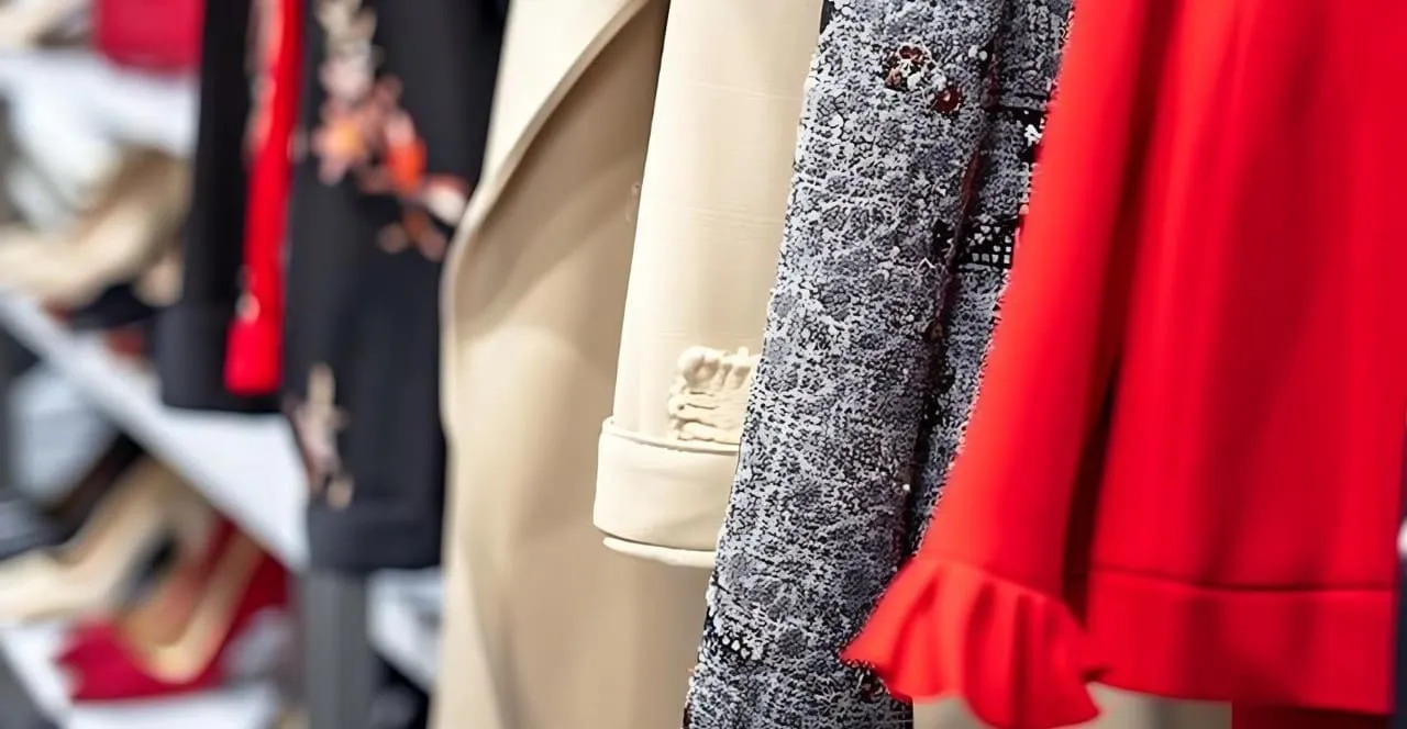 Sélection de vêtements féminins sur un portant avec vestes, robes et pantalons élégants